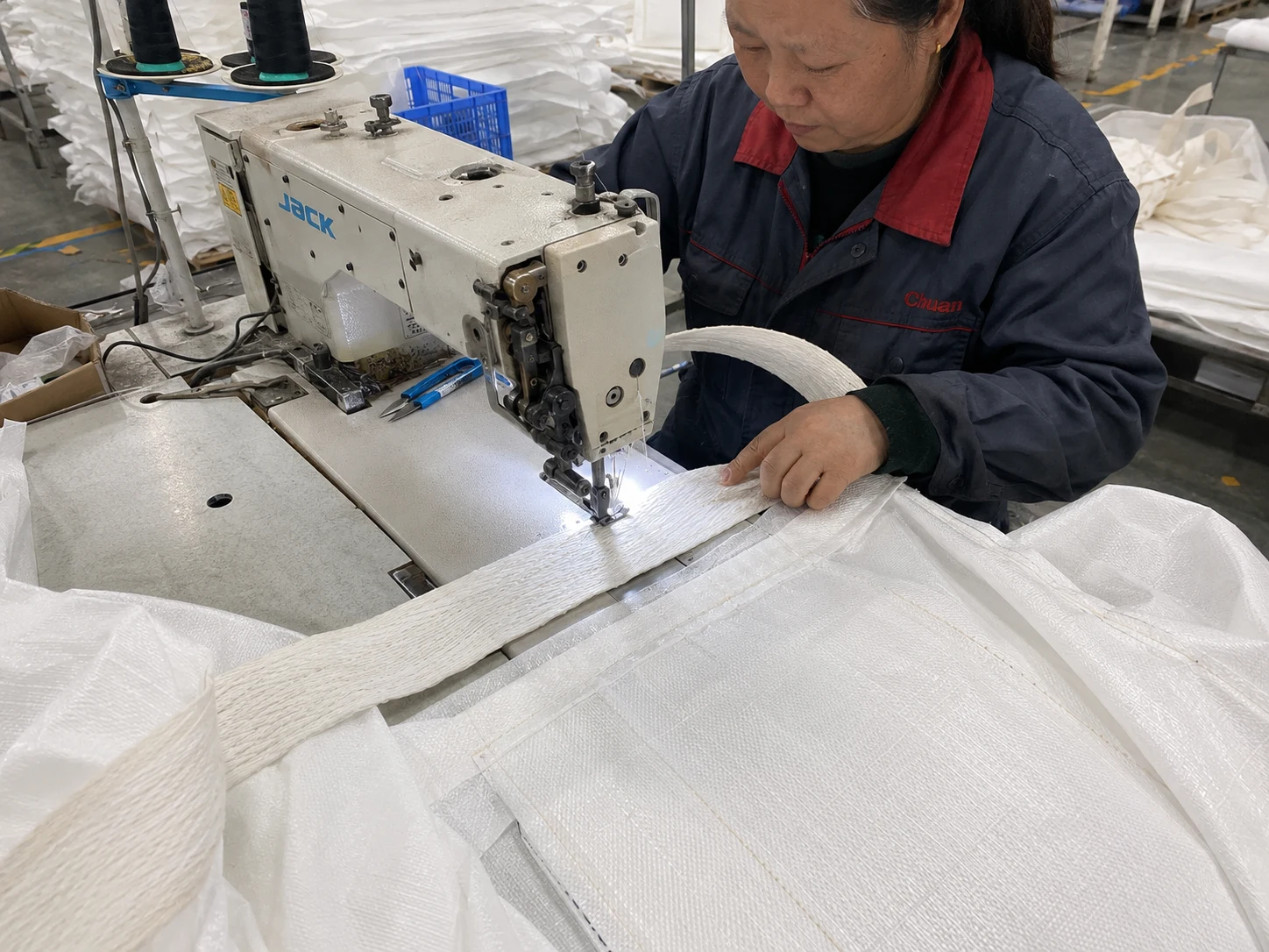 Worker sewing FIBC bulk bag loops on an industrial sewing machine