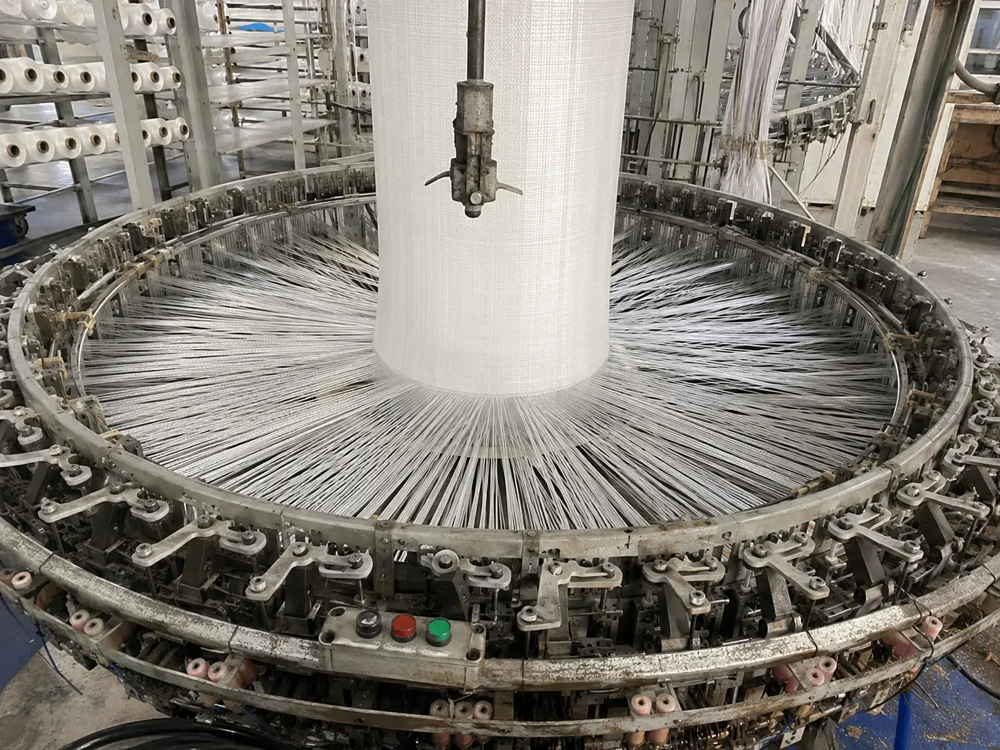 Circular loom weaving polypropylene tape into fabric during FIBC bulk bag manufacturing